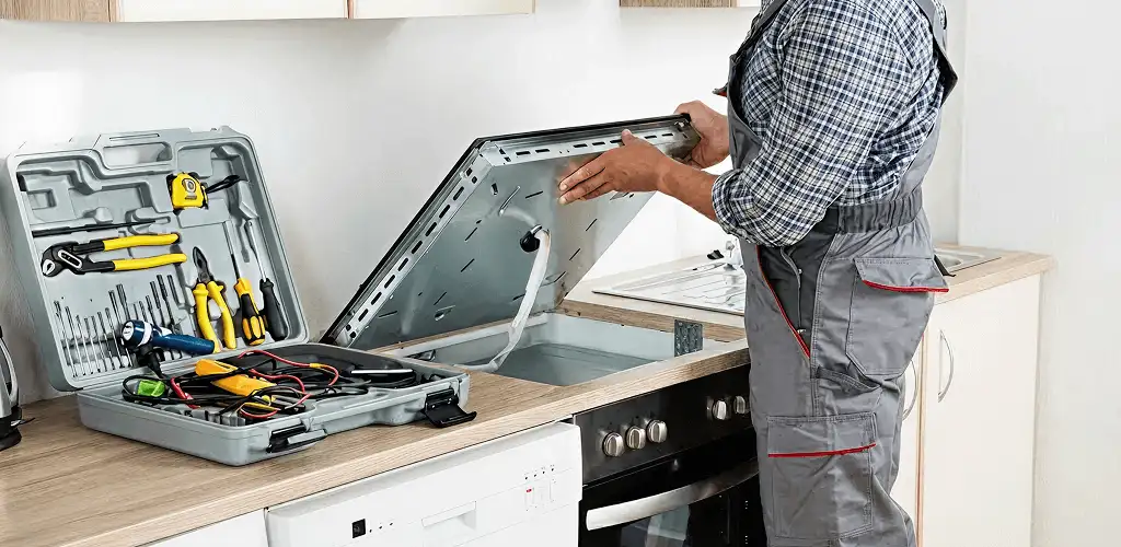 Handyman repairing a cooktop and checking wiring connections in Baltimore, MD