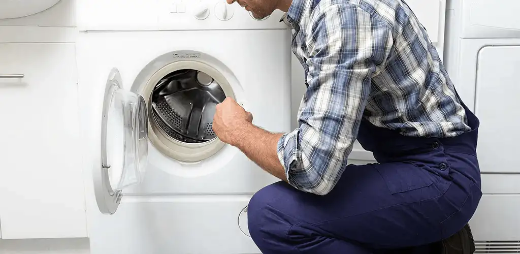 Handyman inspecting a dryer drum and internal parts for repair in Baltimore, MD
