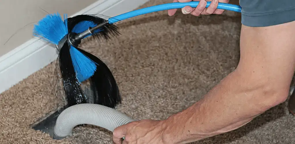 Dryer vent cleaning technician brushing lint from a vent line in Baltimore, MD