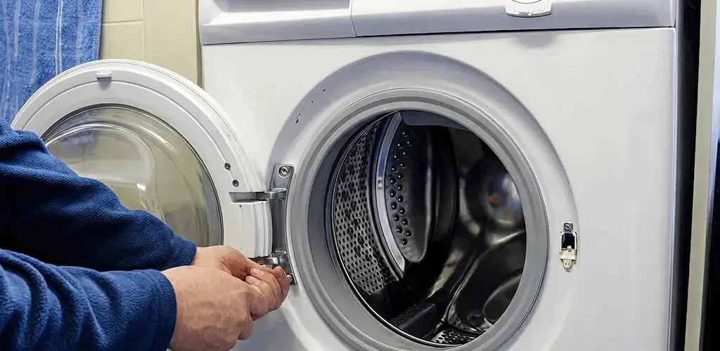 Washing machine repair handyman checking a front-load washer door and latch in Baltimore, MD
