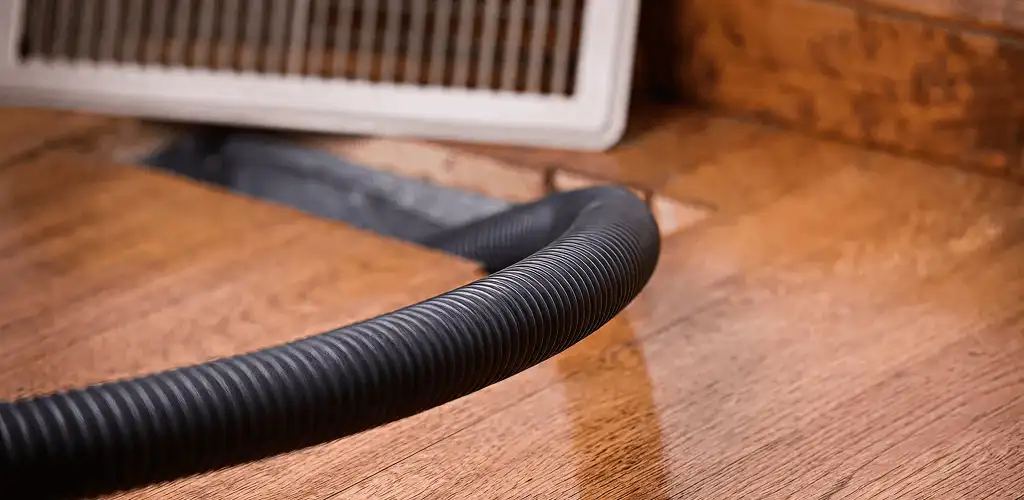 Air duct cleaning hose inserted into a floor vent for ductwork cleaning in Baltimore, MD