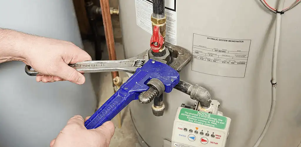 Water heater repair technician tightening the shutoff valve and supply line in Baltimore, MD